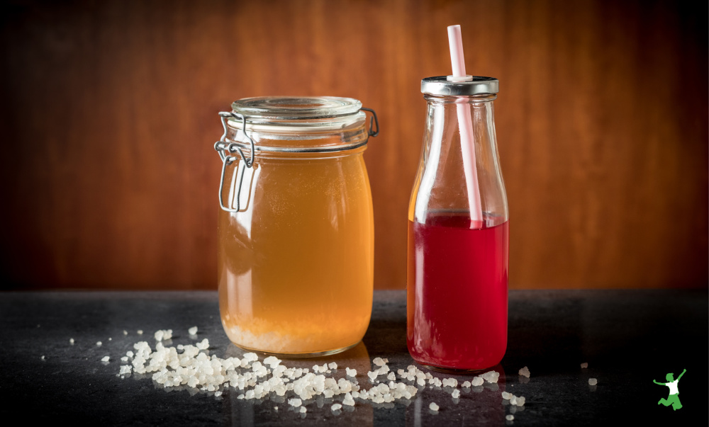 homemade water kefir in a mason jar with bubbly soda in a bottle with straw