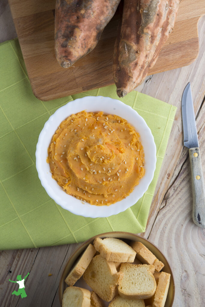 healthy sweet potato hummus on cutting board in white bowl