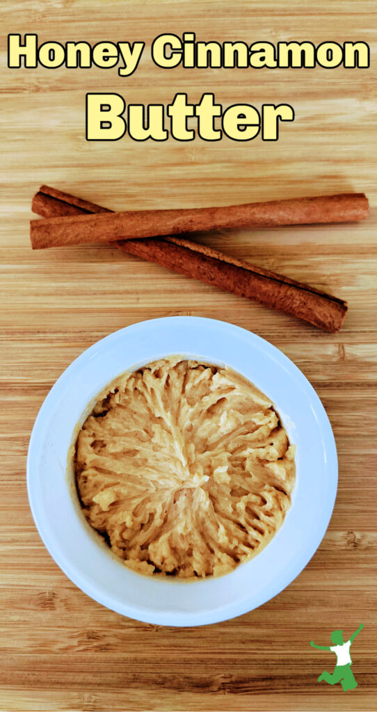 healthy honey butter in white bowl on wooden table with cinnamon sticks