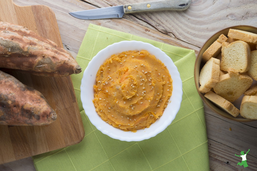 sweet potato hummus in a white bowl on green napkin