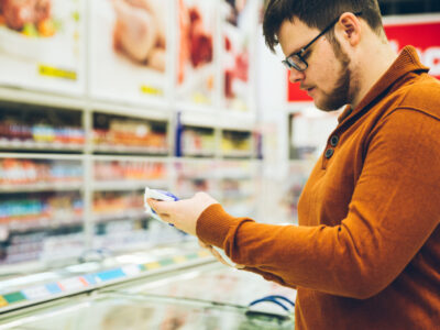 man reading meat label for antibiotic-free