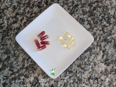 krill oil capsules and cod liver oil on a white plate