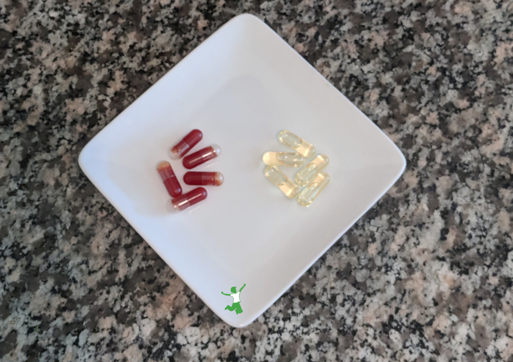 krill oil and cod liver oil capsules on a white plate