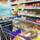 woman holding bottle of hormone disrupting vegetable oil in supermarket