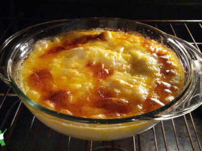 cheesy and creamy seafood casserole in glass baking dish