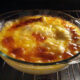 cheesy and creamy seafood casserole in glass baking dish