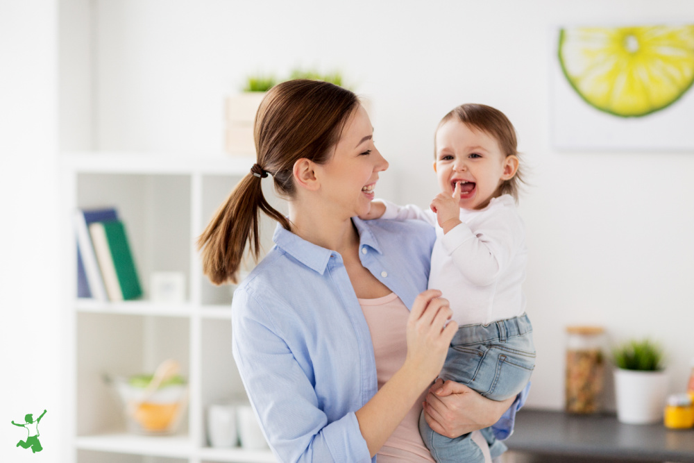 mother holding happy, pain-free teething baby