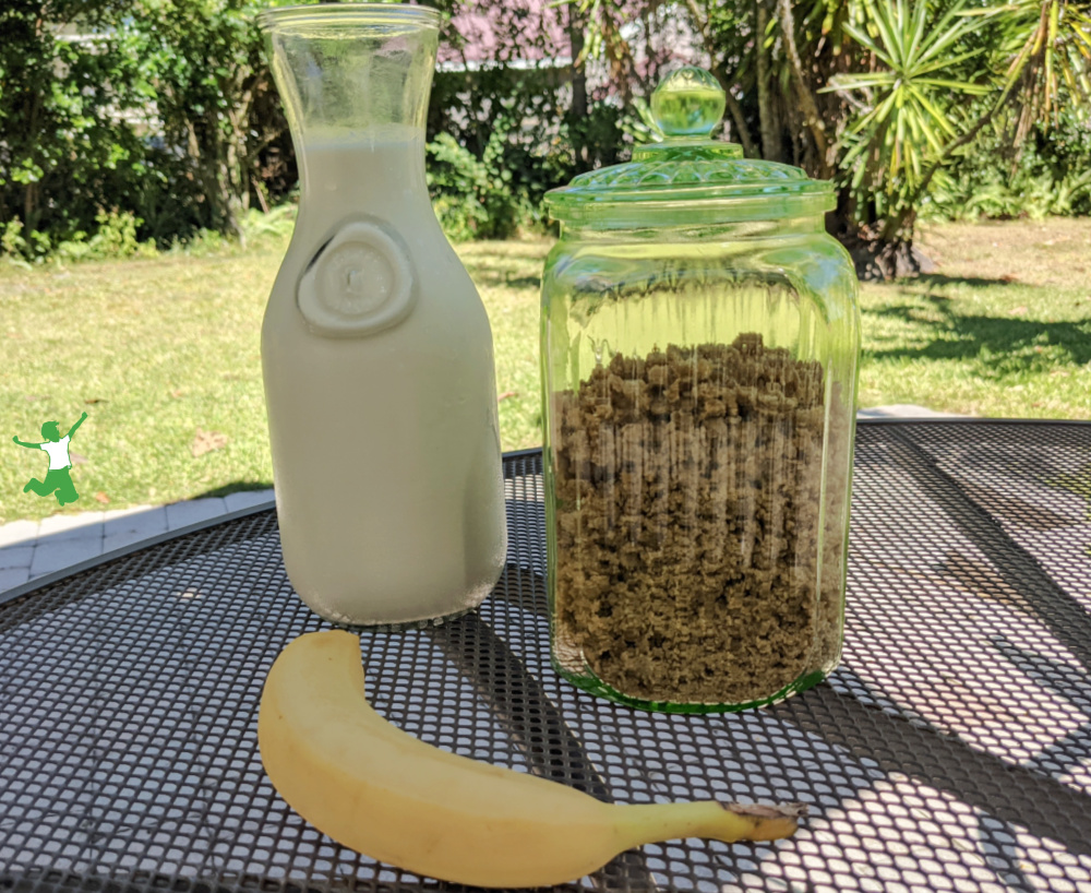 homemade oats and honey cereal with carafe of milk and banana