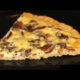 healthy bacon and egg breakfast pizza on black plate