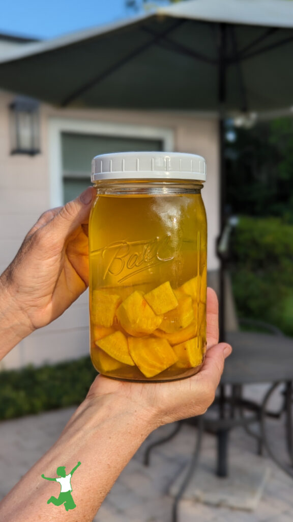 mason jar of cultured golden beet kvass with patio background