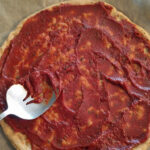 low carb keto pizza crust on parchment paper with topping