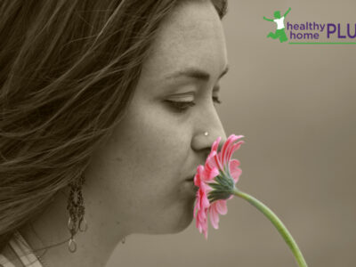 woman with missing tooth holding a pink daisy