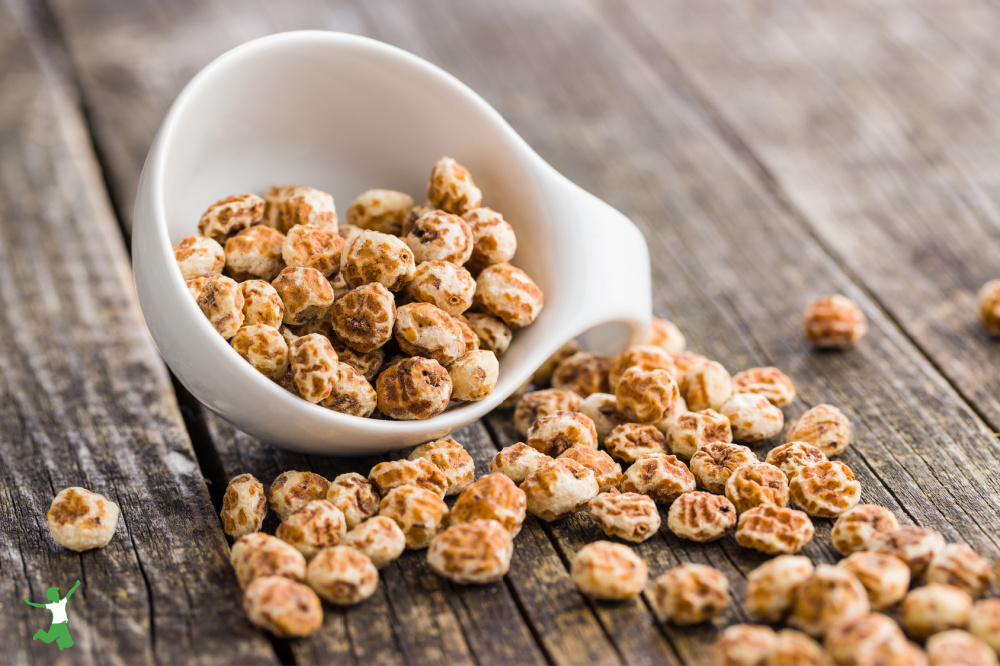 healthy tiger nuts in a white bowl on wooden table