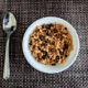 homemade raisin bran in white bowl with spoon