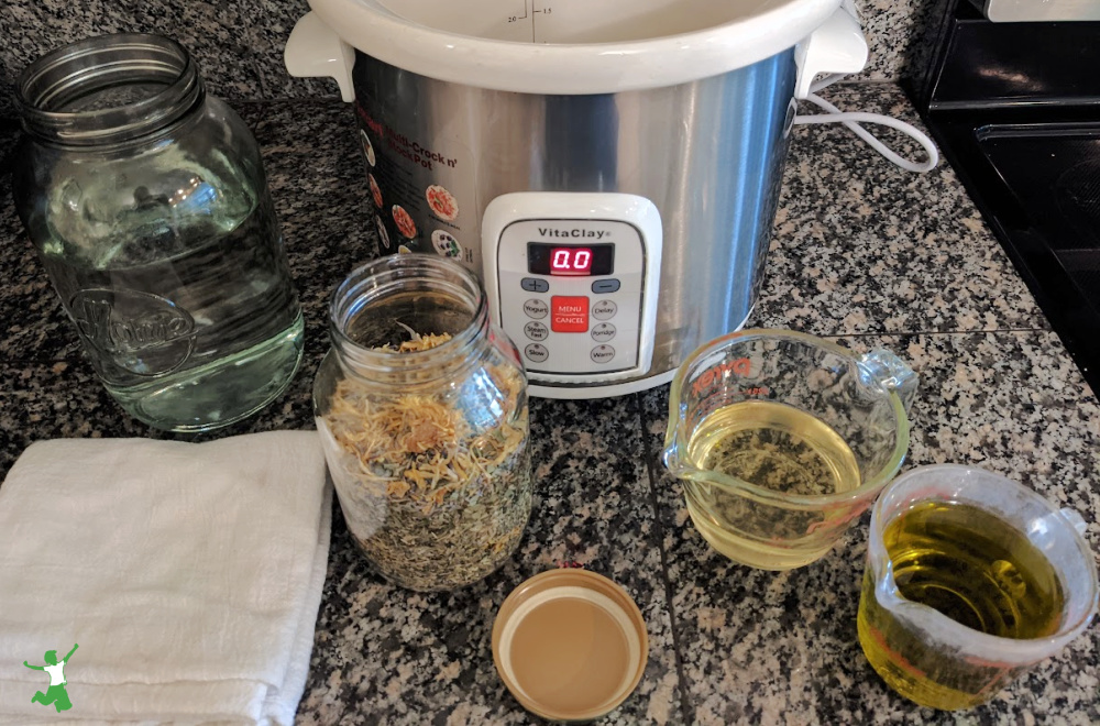 ingredients for making homemade all purpose herbal salve on granite counter