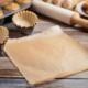 toxic unbleached parchment paper and baking cups with muffins on wooden table