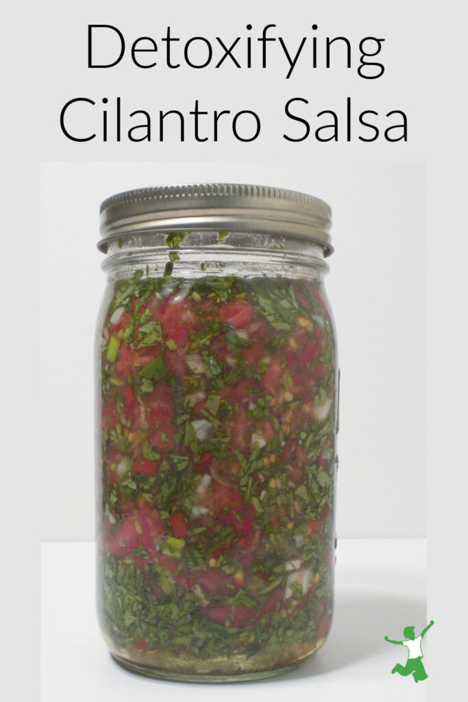 mason jar of chelating cilantro and tomato salsa on white background