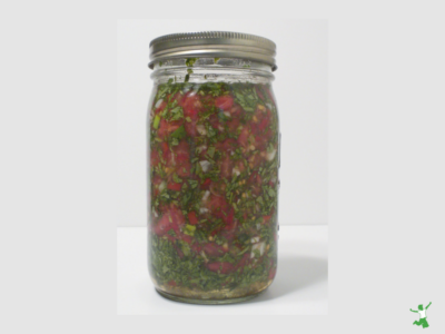 mason jar of chelating cilantro salsa on white background