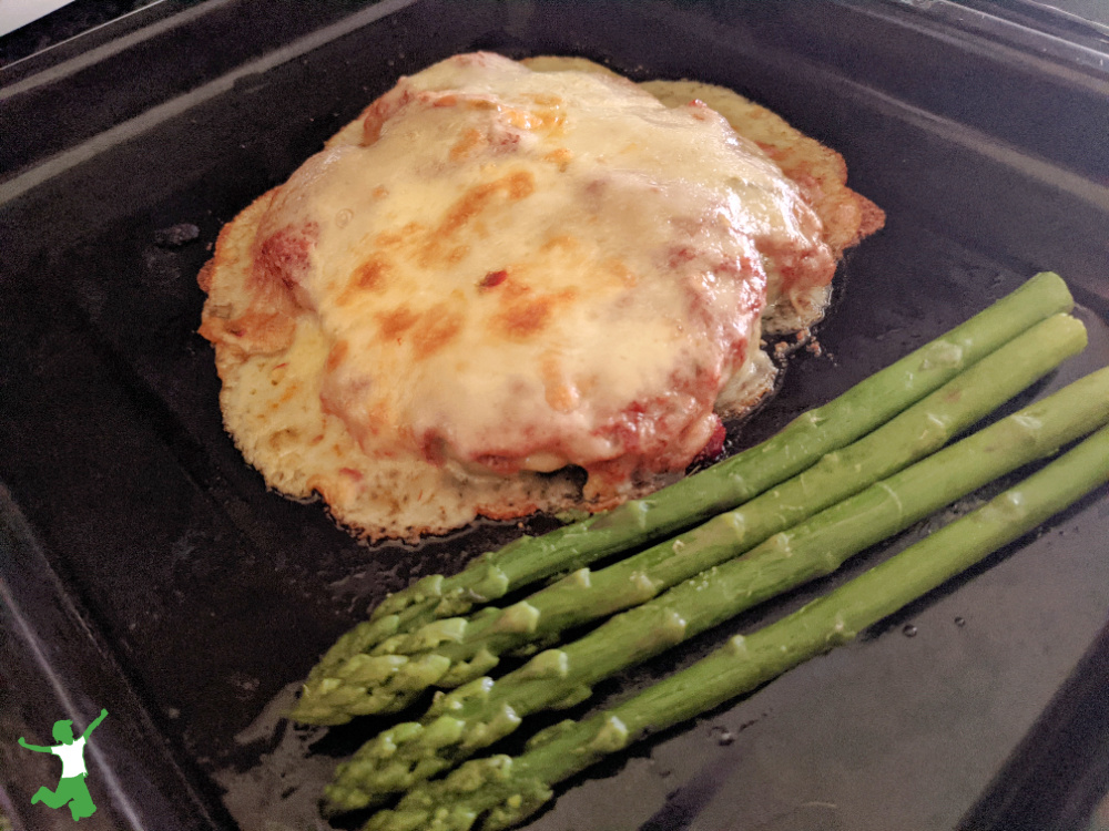 low carb breaded chicken parmesan with asparagus on baking pan