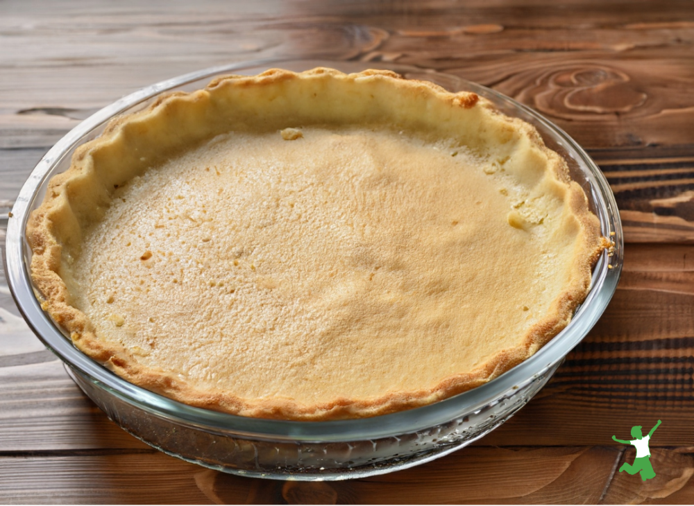 low carb, grain-free keto pie crust in glass pie plate on wooden table