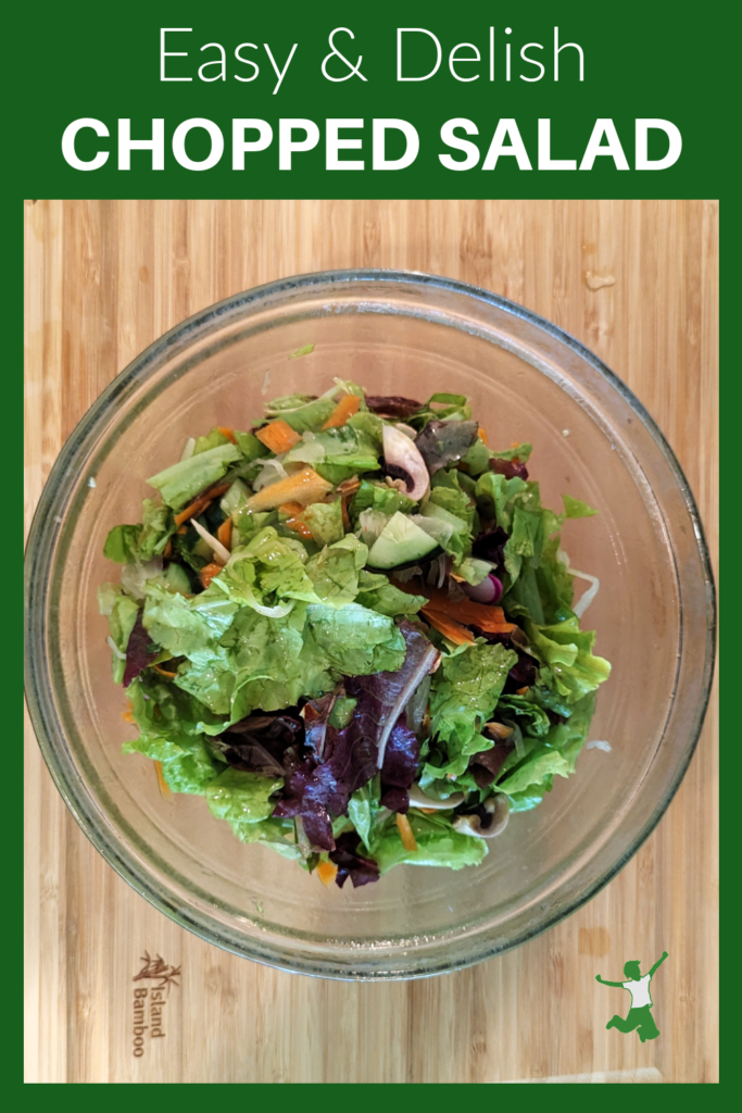 healthy probiotic chopped salad in glass bowl on wood cutting board