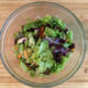 chopped salad in glass bowl with bamboo background