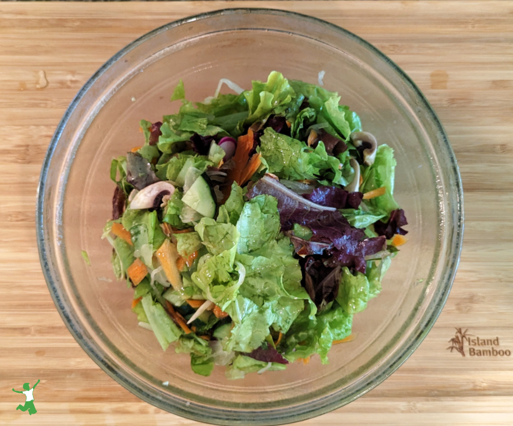 chopped salad in glass bowl with bamboo background