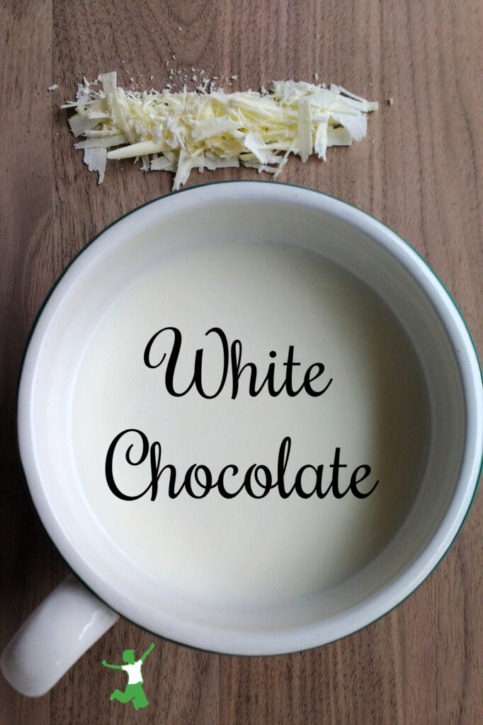 hot white chocolate in a mug on wood cutting board