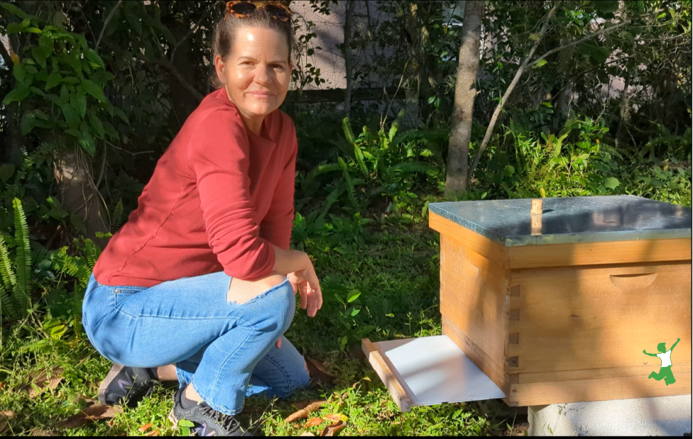 beekeeper adding a bottom board to a hive for warmth