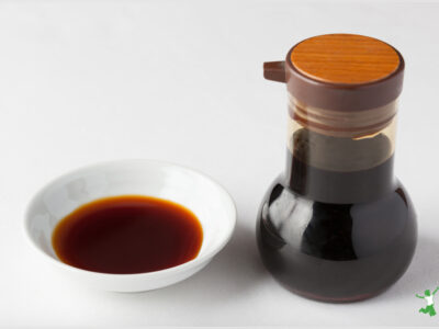 fermented coconut aminos in small white dish and glass bottle