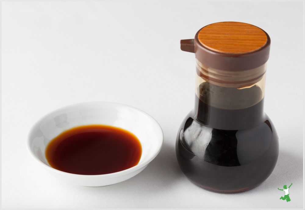 fermented coconut aminos in small white dish and glass bottle