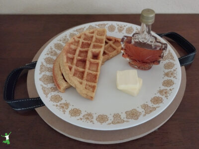 sprouted waffles with butter and maple syrup on white plate