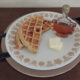 sprouted waffles with butter and maple syrup on white plate