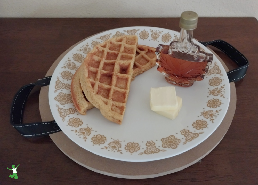 sprouted waffles with butter and maple syrup on white plate