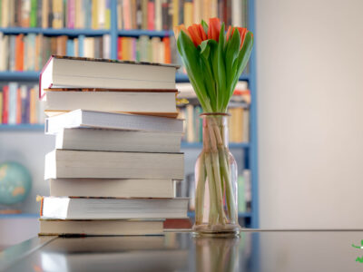 best health books stacked on table with bookshelf in background