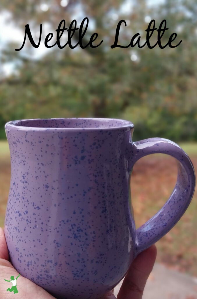 woman holding a nettle latte in speckled mug