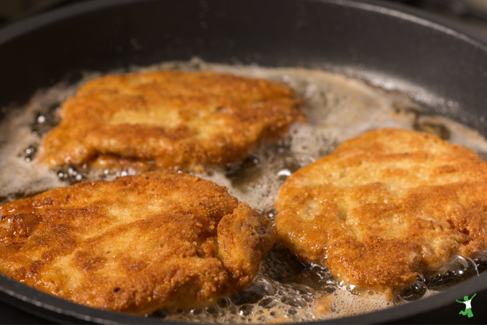 breaded beef heart cutlets frying in a skillet