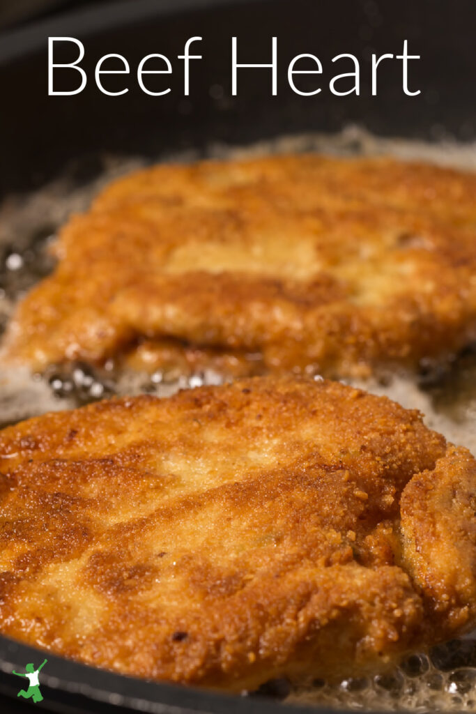 breaded beef heart frying in a skillet