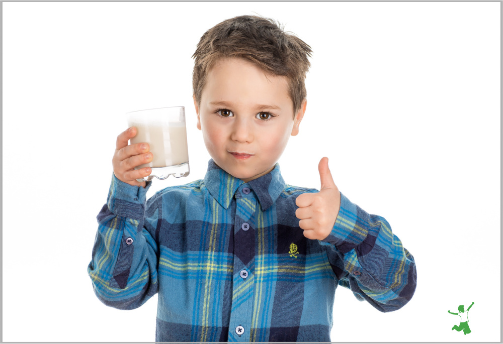 young boy drinking healthy milk substitute in a glass