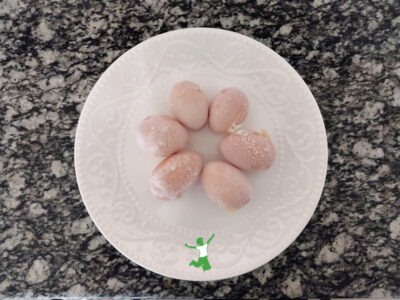 half dozen frozen eggs thawing on white plate