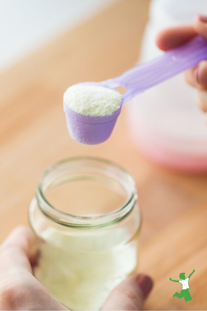 woman adding scoop of milk powder to baby bottle