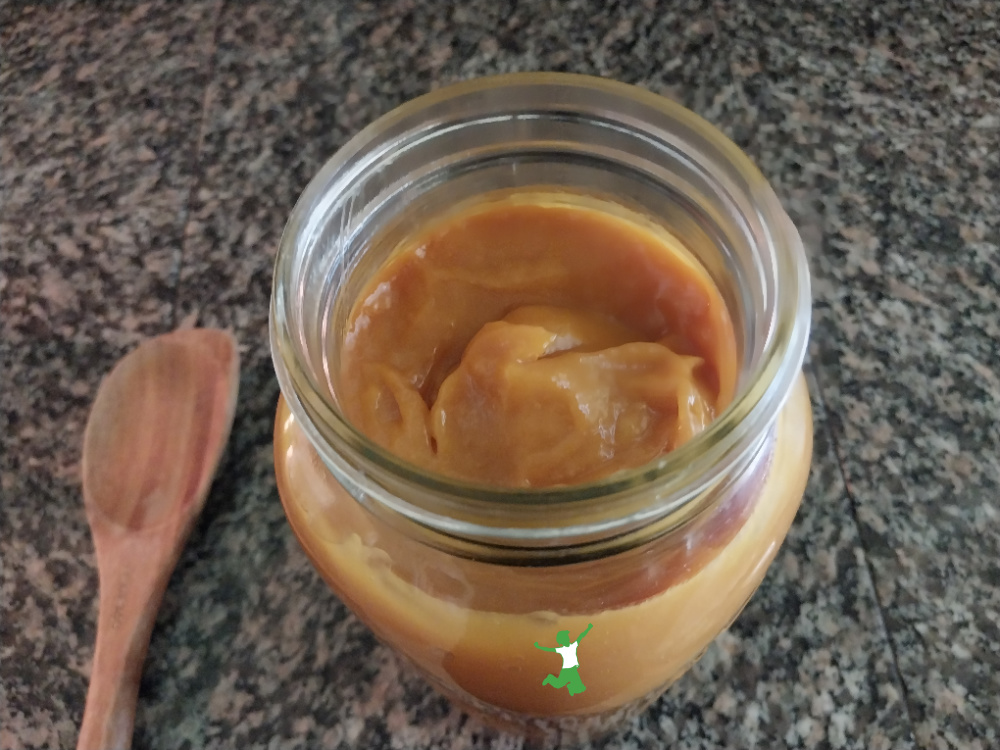 fermented mango butter in mason jar with wooden spoon