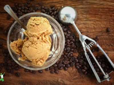 dairy-free coffee ice cream in glass bowl with decaf beans on wooden table