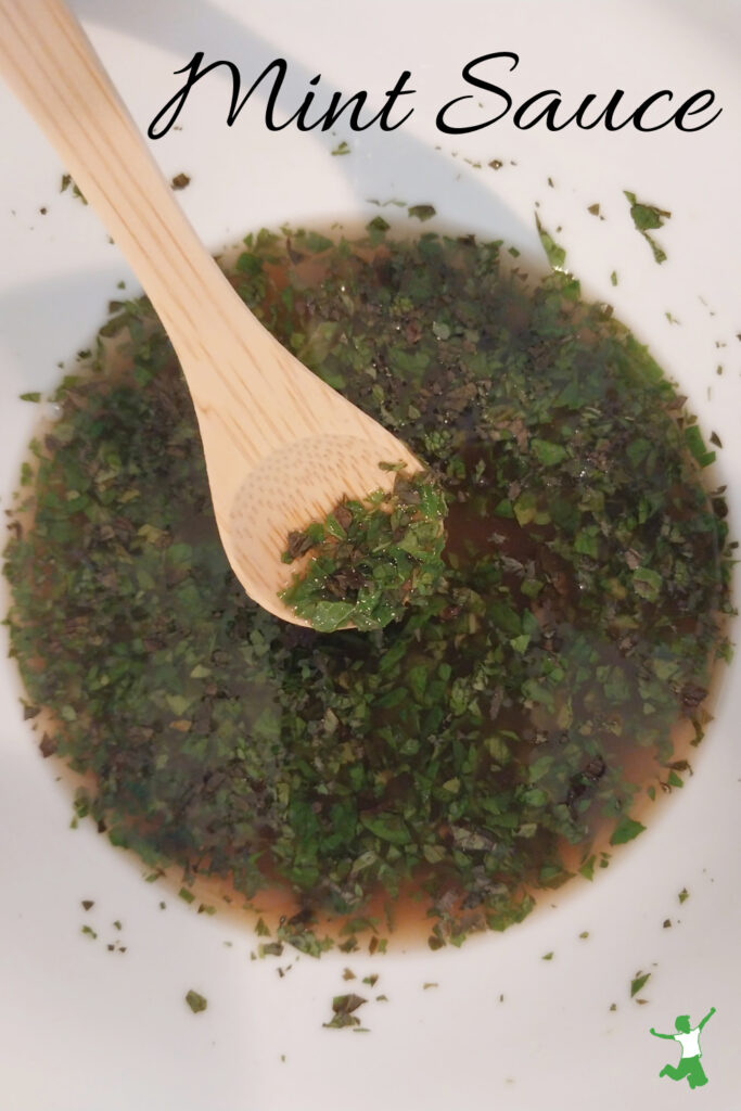 easy mint sauce in white bowl with bamboo spoon