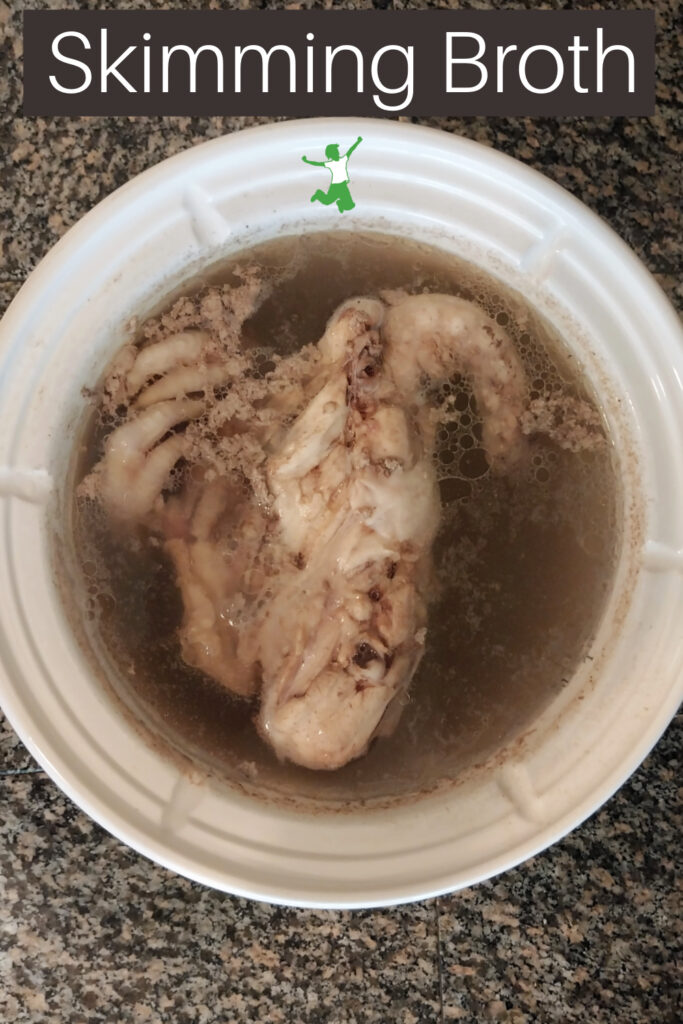 skimmed broth in a white stockpot