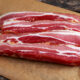 hickory smoked, sugar-free bacon on wood cutting board