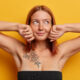 young woman with tattoos on chest and left arm