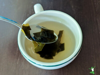 homemade dashi broth in a mug with kombu pieces