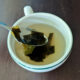 homemade dashi broth in a mug with kombu pieces