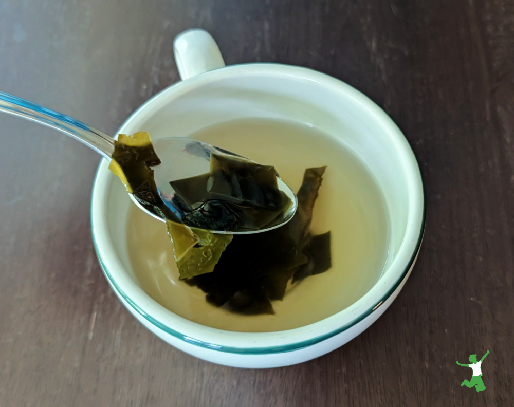 homemade dashi broth in a mug with kombu pieces